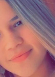 A young woman with long, straight hair smiles softly at the camera