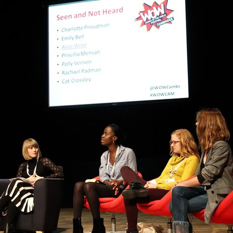 Four women sit on a panel stage with a projected slide titled "Race and Racism"